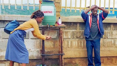 Frau in Afrika nimmt Wasser von einem Wasserspender