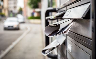 Eine Briefkasten-Anlage mit eingesteckten Prospekten